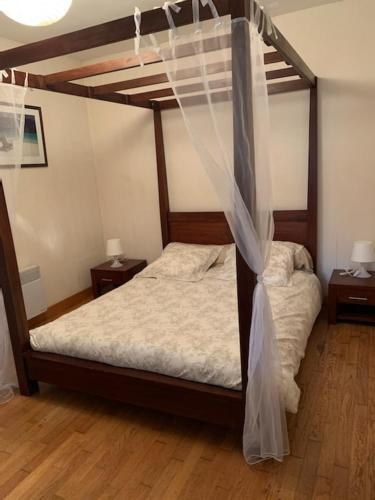 a bedroom with a bunk bed with a mosquito net at Parc an Porz in Lannion