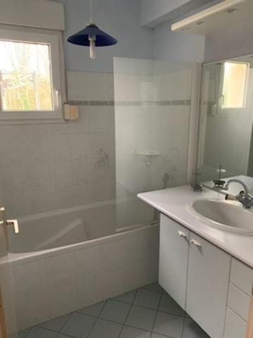 a bathroom with a tub and a sink and a bath tub at Parc an Porz in Lannion