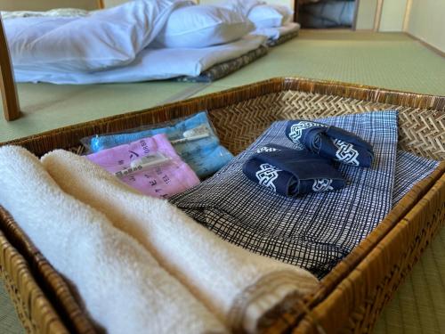 a basket with towels and pillows in a bedroom at Guest House HIIRAGI in Yamanakako