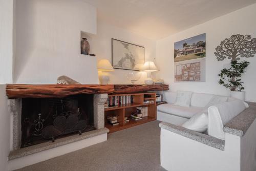 a living room with a fireplace and a white couch at Villa Smeralda Punta Lada Porto Rotondo in Porto Rotondo