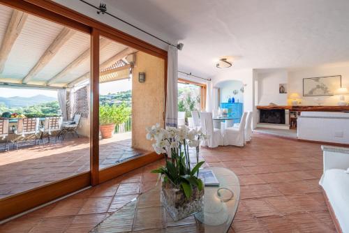 a living room with a large sliding glass door and a dining room at Villa Smeralda Punta Lada Porto Rotondo in Porto Rotondo