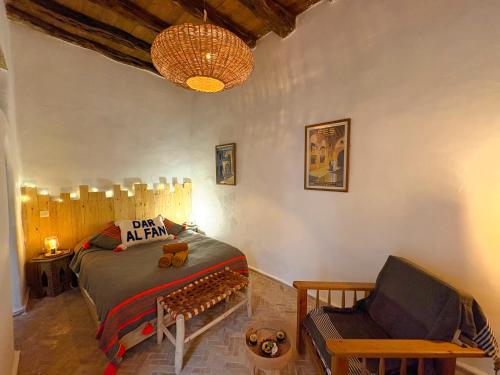 a bedroom with a bed and a chair at Beldi chic & calme, patio végétalisé et terrasse in Essaouira
