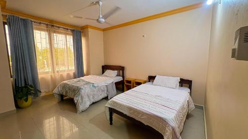 Frere TownにあるChale Apartment 6のベッドが2つと窓のある部屋