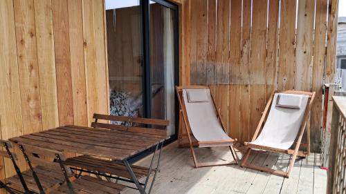two chairs and a wooden table and chairs on a porch at Camping IZARPE in Aróstegui
