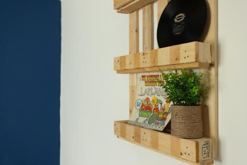 a wooden shelf with a plant and a hat on it at Rena's House - Beach Edition in Tel Aviv