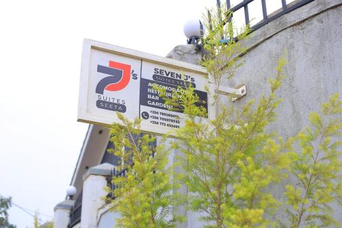 a sign on the side of a building next to a tree at SEVEN J's SUITES in Seeta
