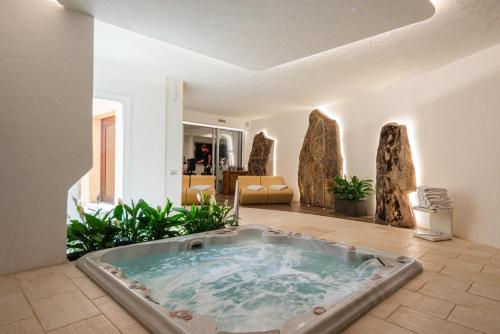 a jacuzzi tub in a room with plants at Villa Smeralda Punta Lada Porto Rotondo in Porto Rotondo