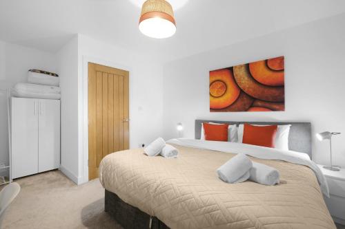 a bedroom with a large bed with a painting on the wall at Eastons 1 Bedroom Apartment with Sofa Bed in High Wycombe