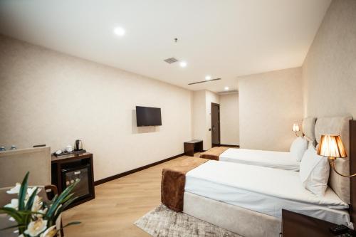 a hotel room with two beds and a tv at Hotel Diamond in Baku