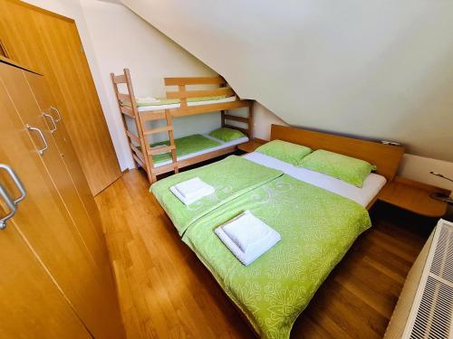 una piccola camera da letto con un letto verde e una scala di Apartma Manca a Kranjska Gora