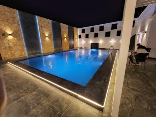 a large swimming pool in a building with blue water at Hotel auroville grand in Covelong