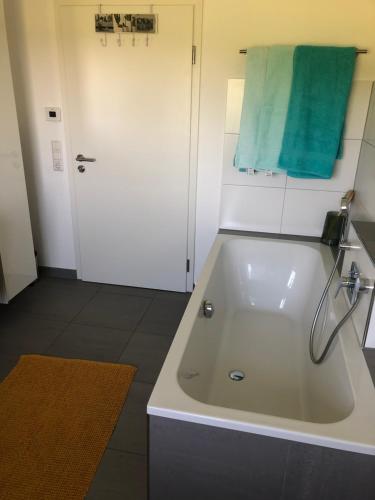 a bathroom with a white tub and a green towel at Landhof Nägele's vom Berg in Argenbühl
