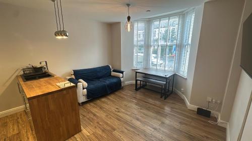 a living room with a blue couch and a table at 7-Min Walk to Principality and City Centre in Cardiff