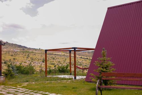 a bench next to a building with a purple wall at IN CLOUDS RESORT Byurakan in Antarut