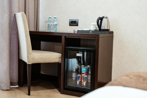a desk with a chair and bottled drinks on it at Hotel Diamond in Baku