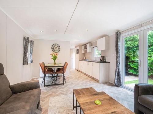 a living room with a table and a kitchen at chalet in the woods with pool in Vledder