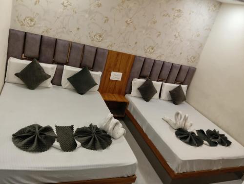 two beds with black and white pillows on them at Grey stone stays-150 meters From Golden Temple in Amritsar