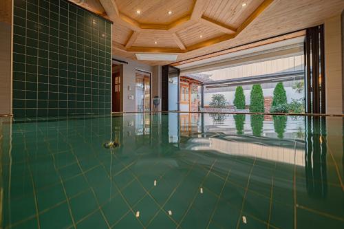 an indoor swimming pool with green flooring and a large window at Dongparang hanok stay in Gyeongju