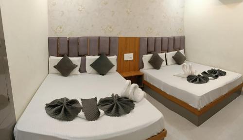 two beds with black and white pillows in a room at Gray Stone- Two mints by walk From Golden Temple in Amritsar