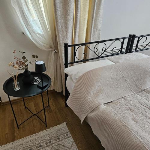 a bedroom with a bed and a table with flowers on it at AC House Apartments in Sarajevo