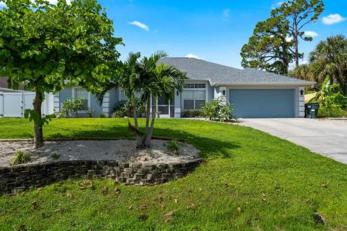 a house with a tree in the front yard at 4 BR Heated Private Pool & Lanai in North Port