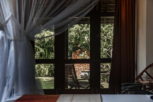 a window with curtains and a door with a view at Dunes Unawatuna Hotel in Unawatuna