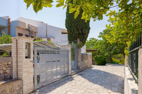 a gate in front of a house with a tree at Agora Apartment in Pythagoreio