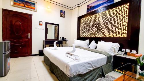 a bedroom with a large bed with swans on it at فندق سمو العرب 