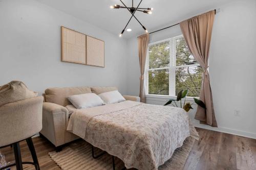 a bedroom with a bed and a couch and a window at Downtown Atlanta Home Away from Home - 2 in Atlanta