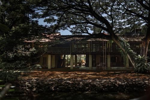 an exterior view of a house with a tree at Dunes Unawatuna Hotel in Unawatuna