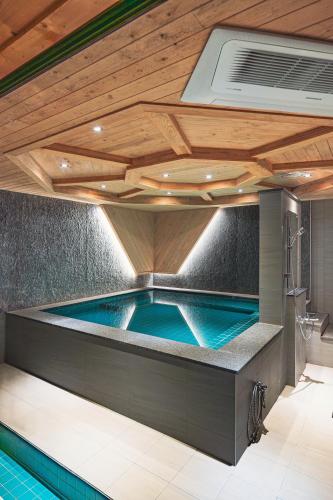a swimming pool in a house with a wooden ceiling at Dongparang hanok stay in Gyeongju