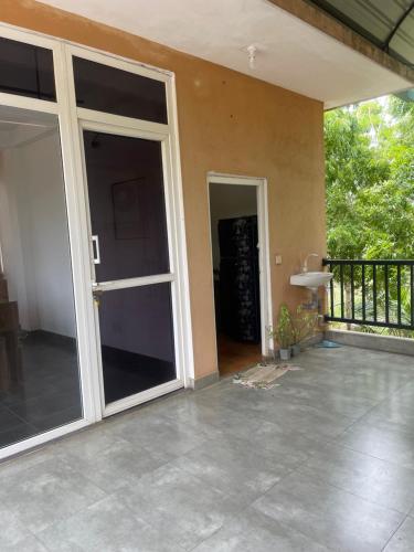 an open sliding glass door of a house at Nature's Hideaway in Anuradhapura