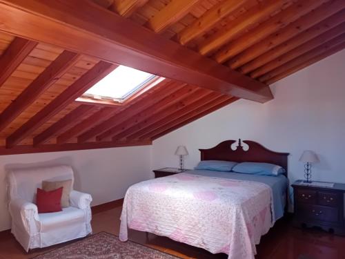a bedroom with a bed and a skylight at Ribeirinha House in Porto Formoso