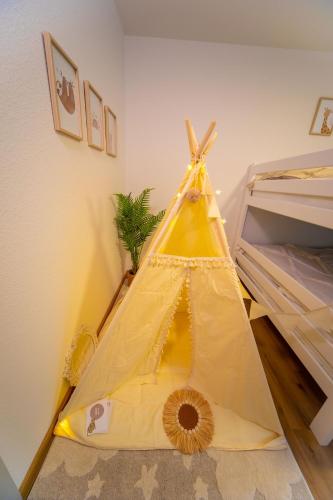 a yellow tent sitting on the floor in a room at P-Hosting BohoStyle Rv1 in Ravensburg