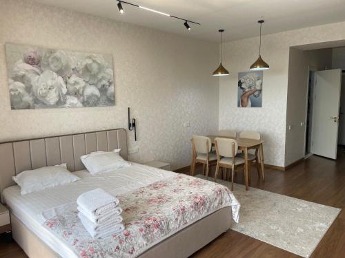 a bedroom with a bed and a table with chairs at U-tower 18 apartment in Chilanzar