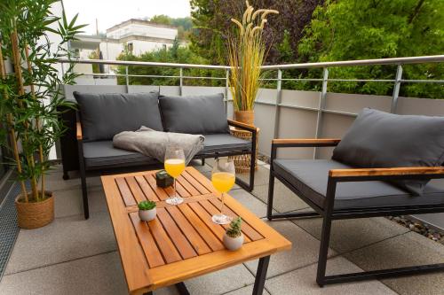 a patio with two chairs and a table with two glasses of orange juice at P-Hosting BohoStyle Rv1 in Ravensburg