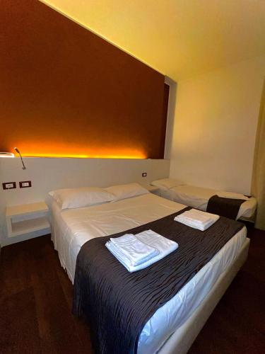 a hotel room with two beds with towels on them at Hotel Aragosta in Cattolica