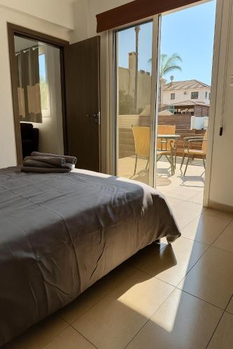 a bedroom with a bed and a view of a patio at Sunflight Apt 01B One Bedroom Apt in Larnaka