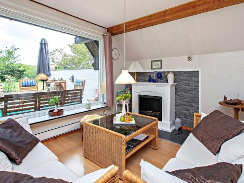 a living room with white furniture and a fireplace at 4 star holiday home in Væggerløse in Bøtø By