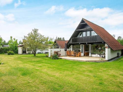 a house with a gambrel roof and a yard at 4 star holiday home in Væggerløse in Bøtø By