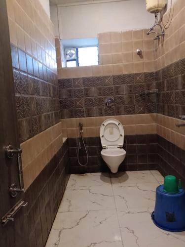 a bathroom with a toilet in a tiled room at Royal SeaView in Digha