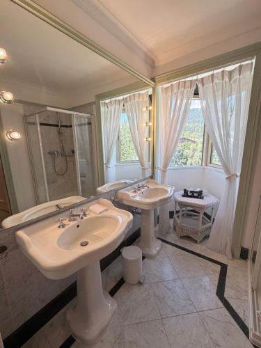a bathroom with two sinks and a shower at Grand Hôtel du Golf & Palace in Crans-Montana