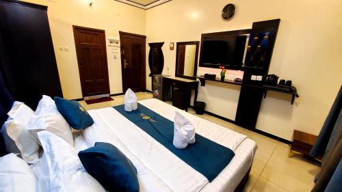 a bedroom with a large white bed with blue pillows at فندق سمو العرب 