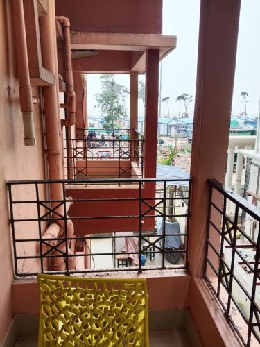 a yellow chair on the balcony of a building at Royal SeaView in Digha