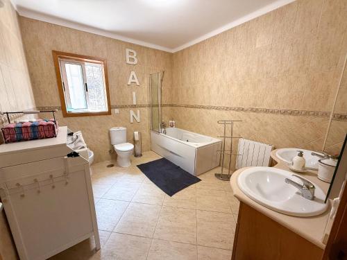 Un baño con bañera, inodoro y lavabo. en Cerca do casal, en Santo Tirso
