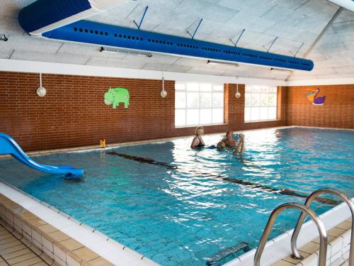 two people swimming in a large swimming pool at 6 person holiday home in Rømø in Rømø Kirkeby