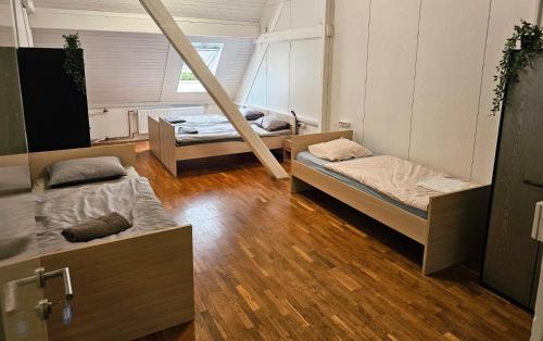two beds in a room with wooden floors at Hostel pod gradom in Celje