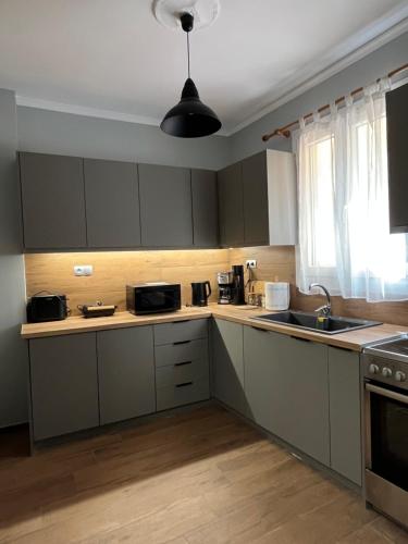 a kitchen with white cabinets and a sink at Kountouriotou 24 hospitality in Chios