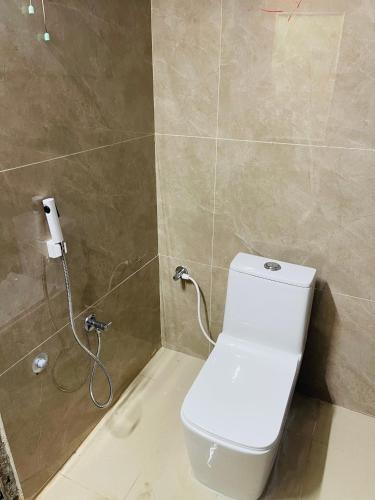 a bathroom with a white toilet and a shower at Nirai Homestays in Madurai