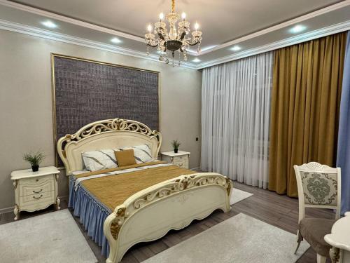 a bedroom with a large bed and a chandelier at Promenade EXPO in Astana